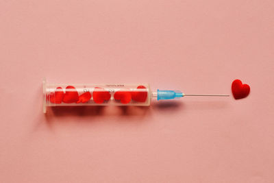 Close-up of syringe against yellow background