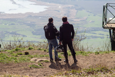 Rear view of men standing on land