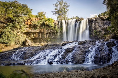 Scenic view of waterfall against sky