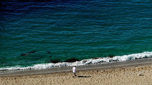 Man standing on beach by sea