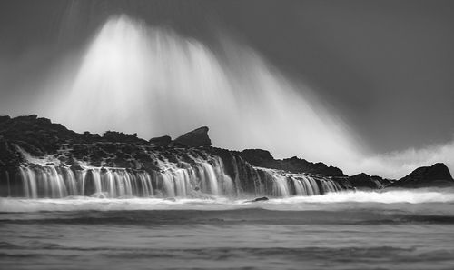 Scenic view of waterfall against sky