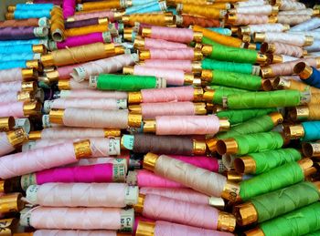 Close-up of colorful thread spools displayed for sale