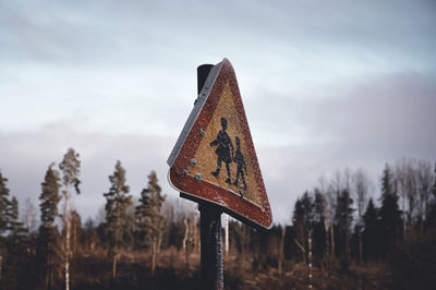 Close-up of road sign against sky