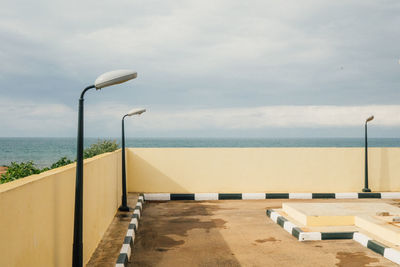Street light by sea against sky
