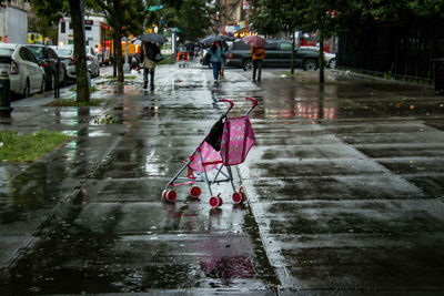 People walking on wet footpath during rainy season