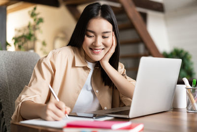 Young woman using laptop at table