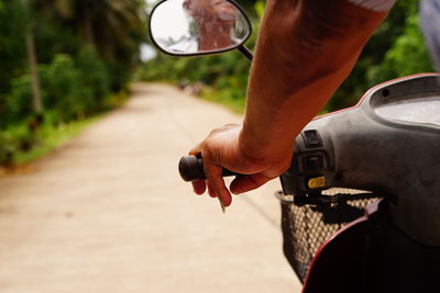 Close-up of man holding bicycle on road