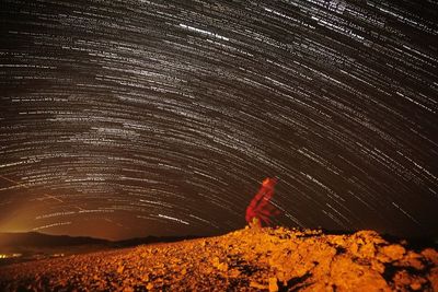 Person standing on rock at night