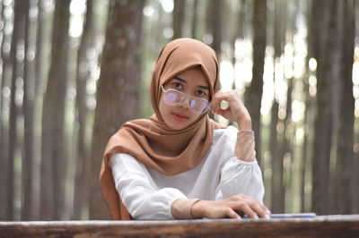 Portrait of young woman wearing hijab at forest