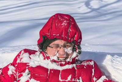 Man having fun in the forest swimming in the snow