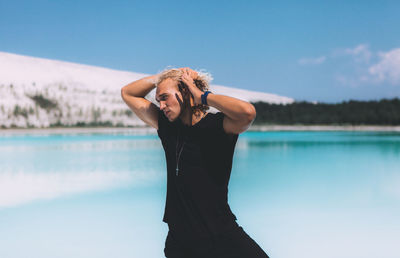 Woman standing in water against sky