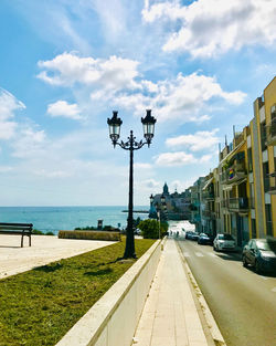 Street by sea against sky in city