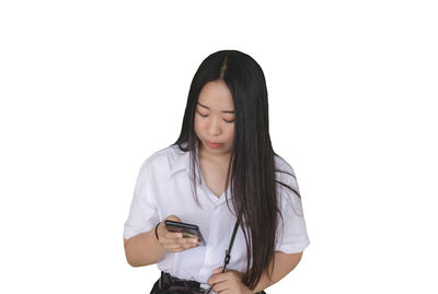 Young woman using mobile phone against white background