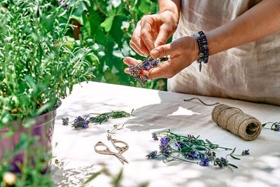 Herbalist woman preparing fresh scented organic herbs for natural herbal methods of treatment.