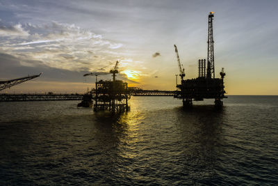 Silhouette of oil production platform during sunset at oil field