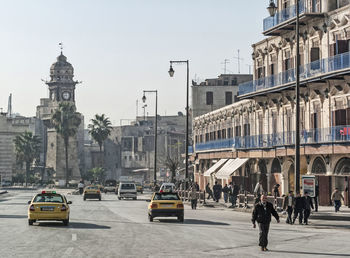 View of city street and buildings against sky