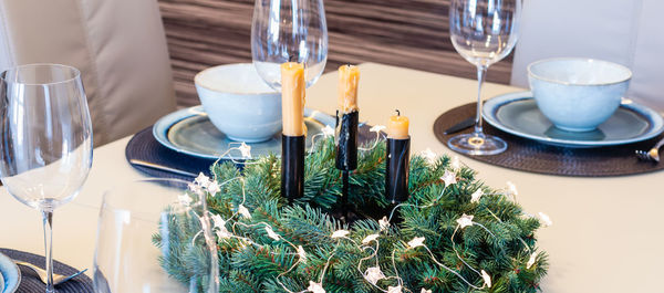 Christmas festive table decoration with spruce wreath and stars garland. 