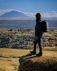 Rear view of man standing on rock