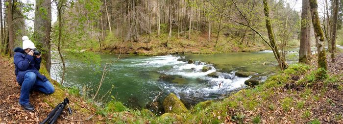 Man standing by river in forest