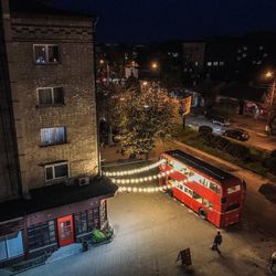 High angle view of illuminated street amidst buildings in city at night