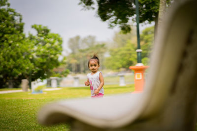 Full length of smiling girl playing in park