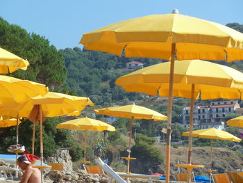 Multi colored umbrellas on beach against sky