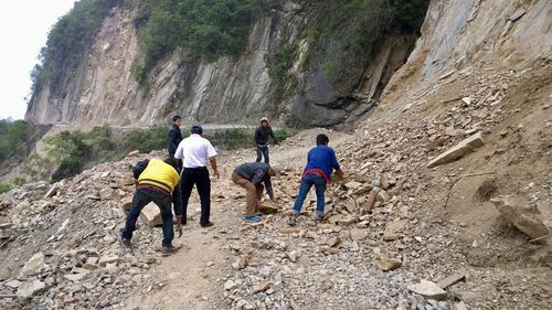 Rear view of people walking on rocks