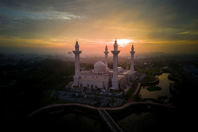 High angle view of mosque in city during sunrise