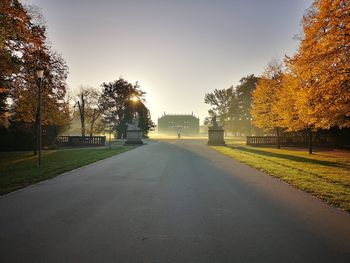 Road amidst trees against sky during autumn