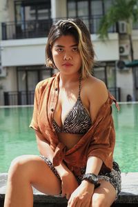 Portrait of beautiful woman sitting in swimming pool