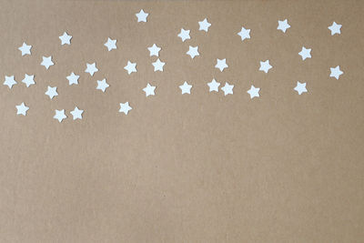High angle view of star shape papers against brown background