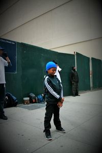 Full length of boy standing on umbrella