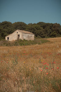 House on field against clear sky