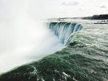 Scenic view of waterfall against sky