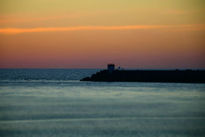 Scenic view of sea against orange sky