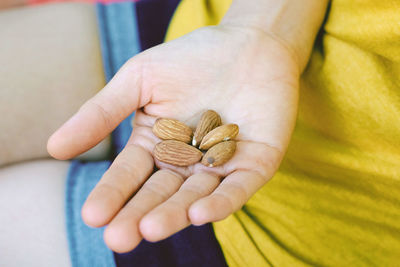 Midsection of woman holding almonds