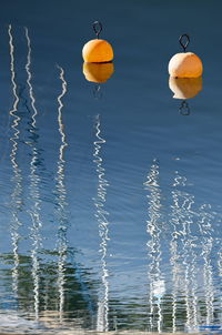 Close-up of crystal ball hanging over lake against sky