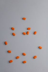 High angle view of orange berries on white background