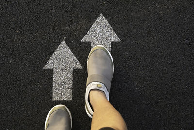 Low section of man standing on road