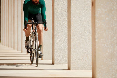 Rear view of man riding bicycle on street