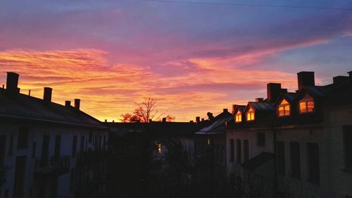 Houses against sky at sunset