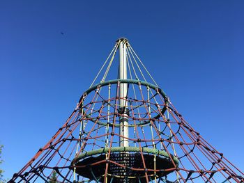 Low angle view of ferris wheel against clear blue sky