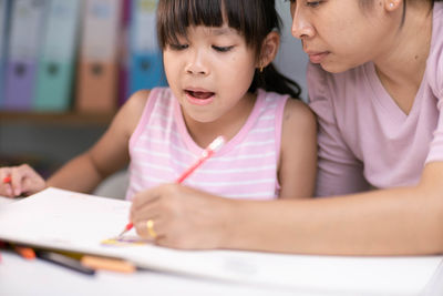 Close-up of girl studying at home