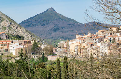 Panoramic view of townscape and mountains against clear sky