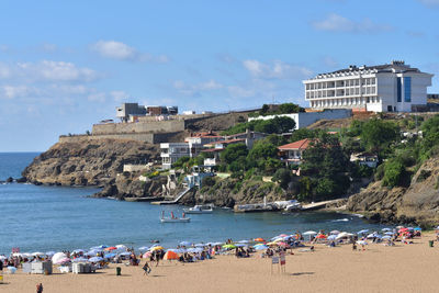 People at beach against sky
