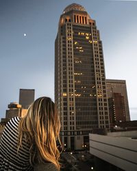 Rear view of woman against buildings in city