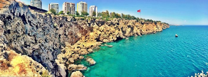 Panoramic view of blue sea by wall on sunny day