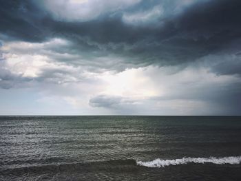 Scenic view of sea against storm clouds