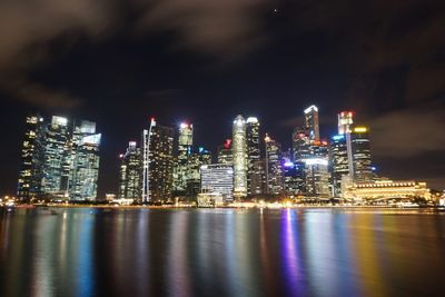 Illuminated cityscape against sky at night