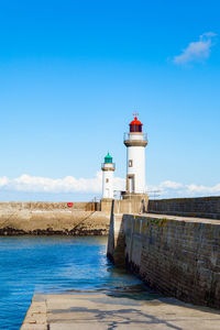 Lighthouse by sea against sky